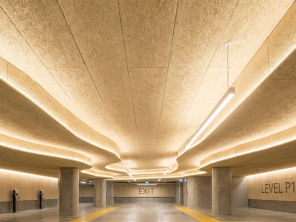 Plafond en panneaux de laine de bois Fibralith dans un parking souterrain éclairé par des rubans LED.