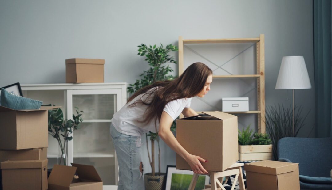 Femme préparant des cartons dans un salon avant un déménagement