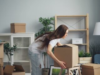 Femme préparant des cartons dans un salon avant un déménagement