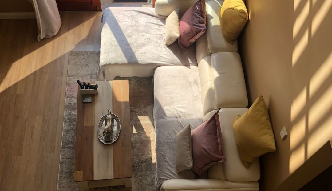 Petit salon lumineux avec canapé modulable, table basse et lumière naturelle