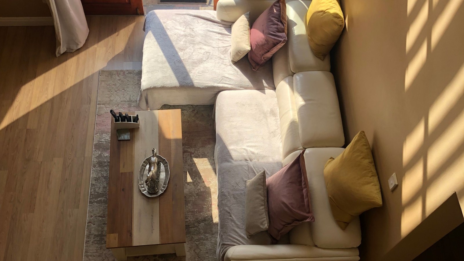Petit salon lumineux avec canapé modulable, table basse et lumière naturelle