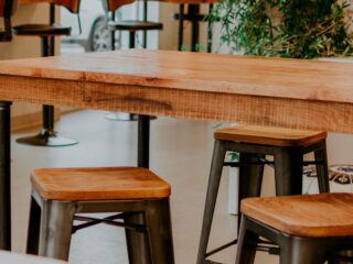 Table en bois massif et tabourets en métal dans un intérieur industriel